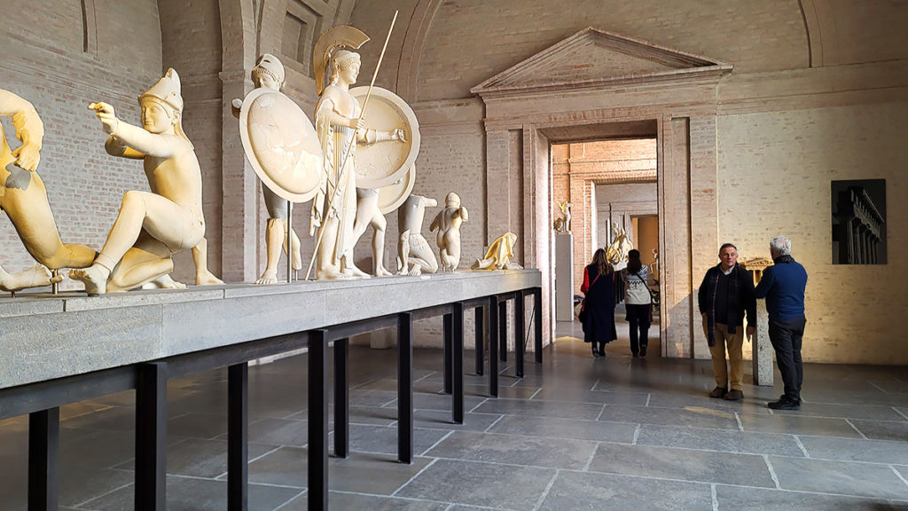 Besucher:innen der Ausstellung "Griechische Tempel" mit Fotografien von Richard Berndt und und antiken Skulpturen in der Glyptothek in München